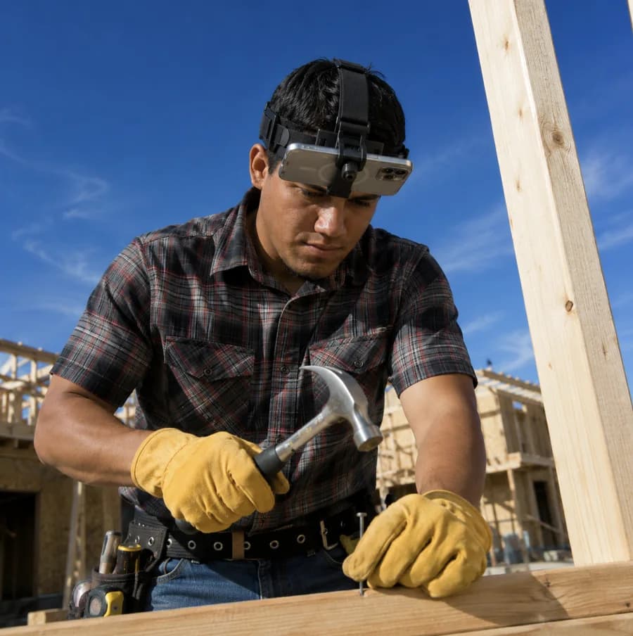Carpenter wearing the Shift headset while hammering timber